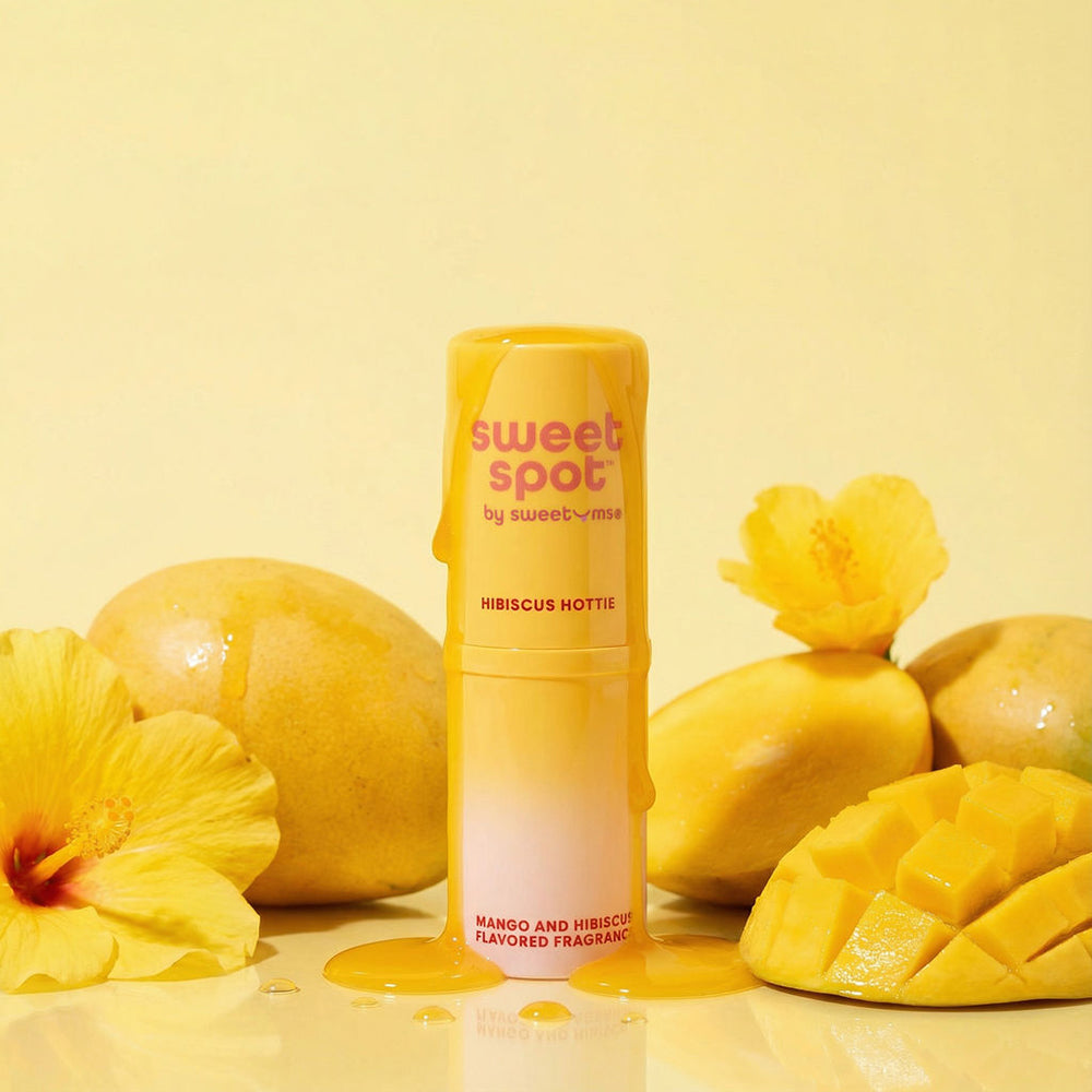 Sweetums Sweet Spot Flavored Fragrance Hibiscus Hottie with mango and hibiscus on a yellow background.