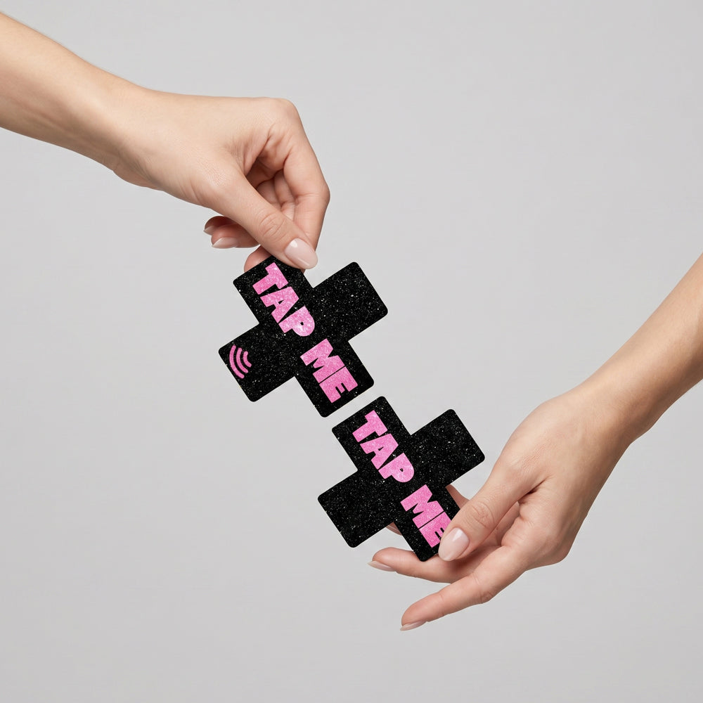 Neva Nude Tap Me Pink X Smart Nfc Pasties held between two hands, showcasing fashionable design and NFC technology.
