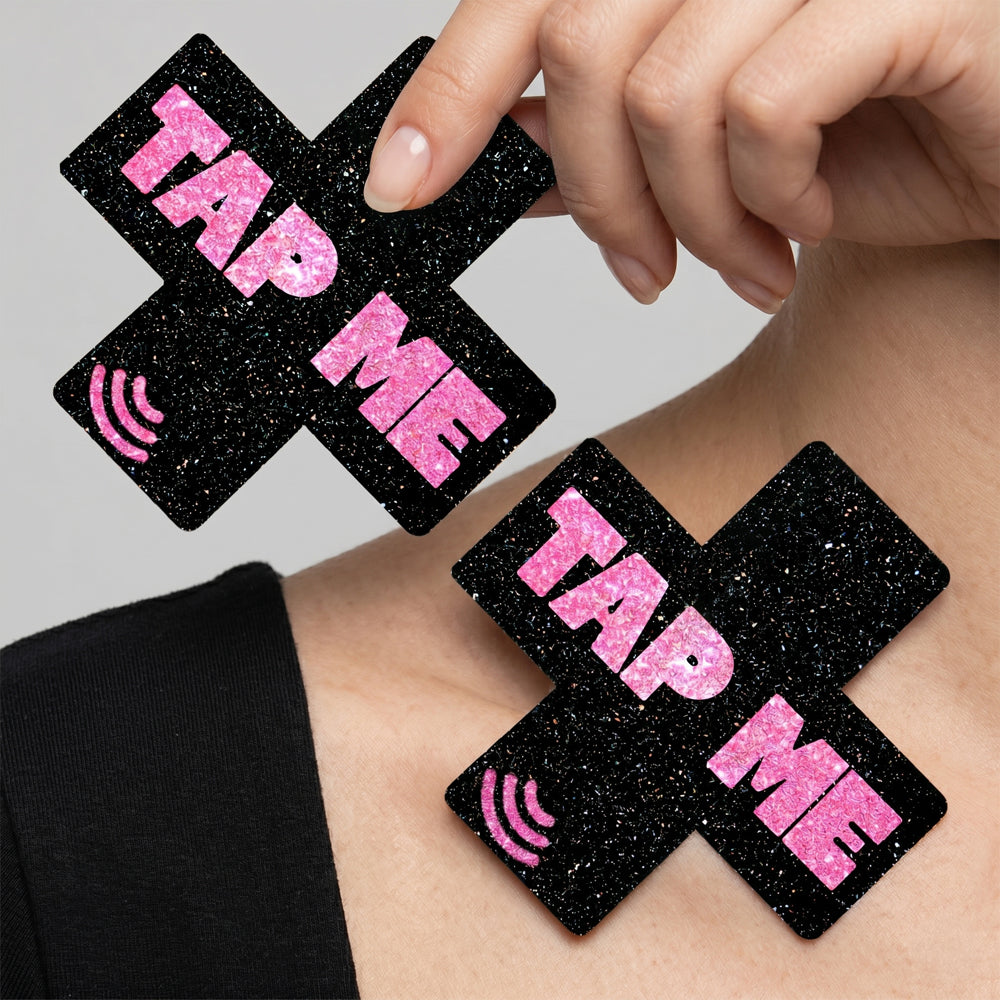 Neva Nude Tap Me Pink X Smart Nfc Pasties in black with pink glitter 'TAP ME' text on model's shoulder.