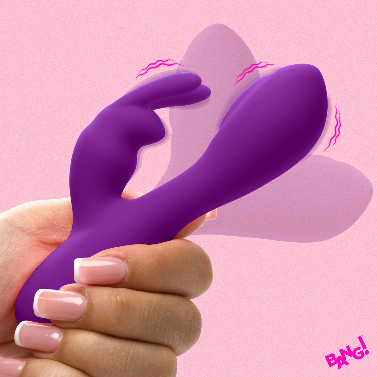 Bang Flexible Silicone Mini Rabbit Vibrator Purple held in a hand against a pink background, showcasing its flexible design.