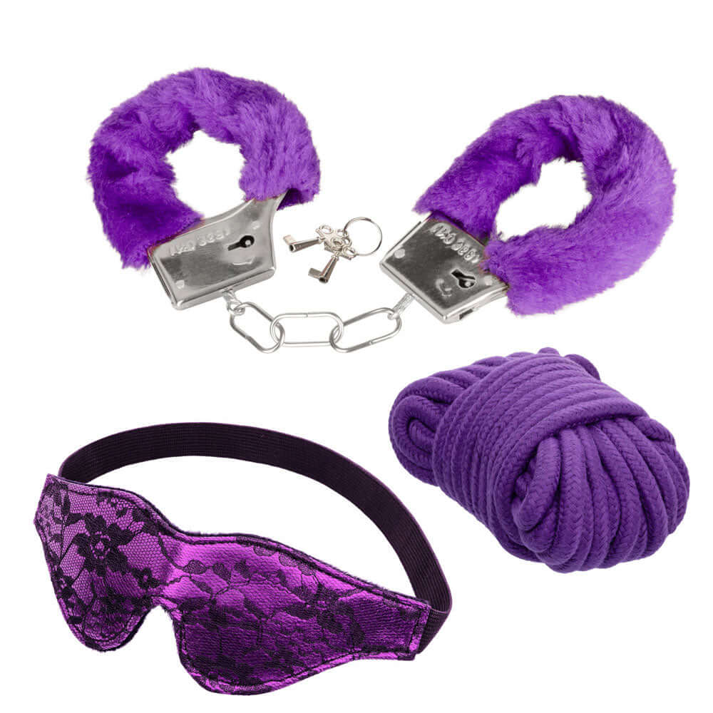 Pleasure Kits Indulgent Collection Purple comprising purple fur handcuffs, lace eye mask, and rope for intimate exploration.