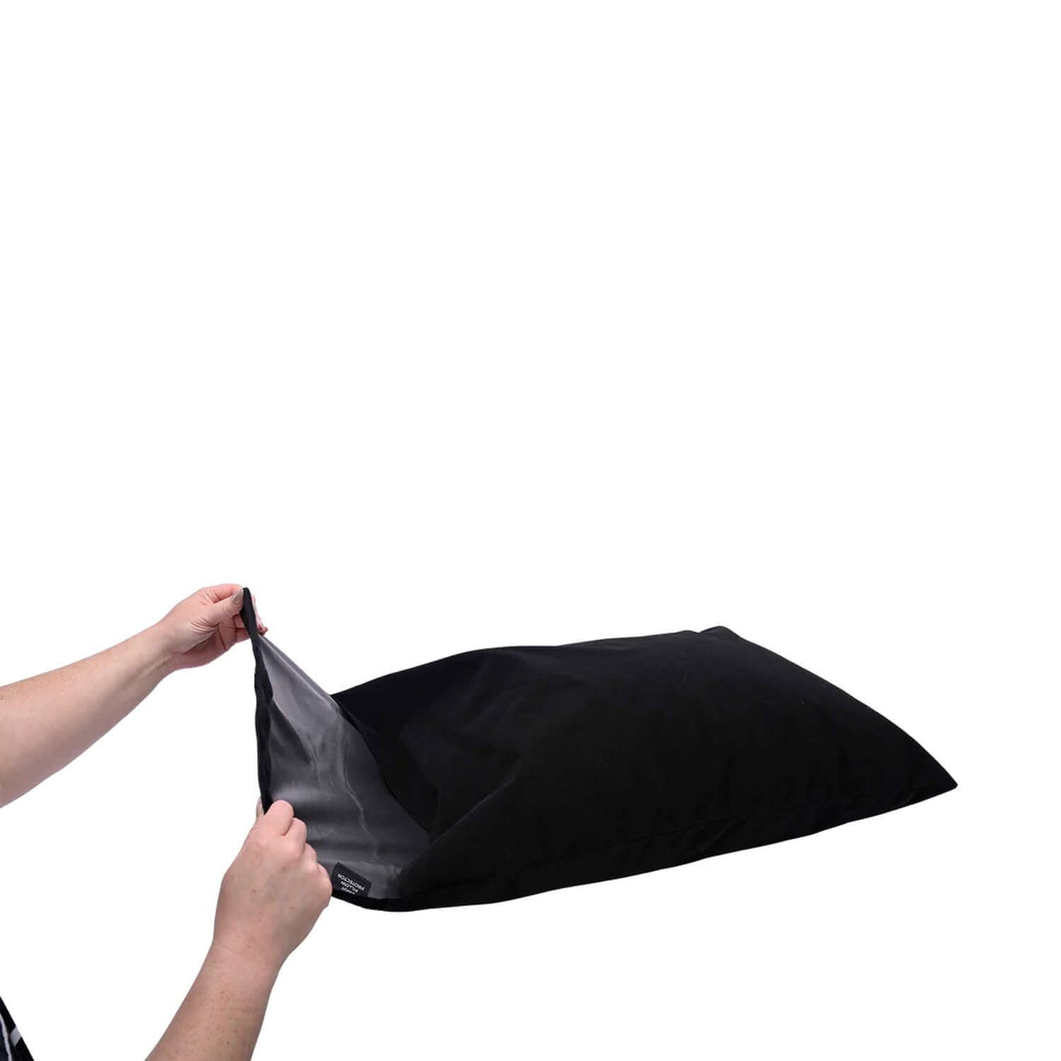 Person holding a black Pivot Pillow Protector with hook and loop closure, showcasing its versatility and premium protection.