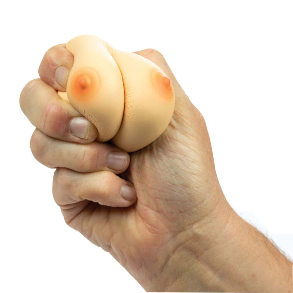A hand squeezing a soft novelty toy designed for stress relief, featuring Stress Breasts for fun tension release.