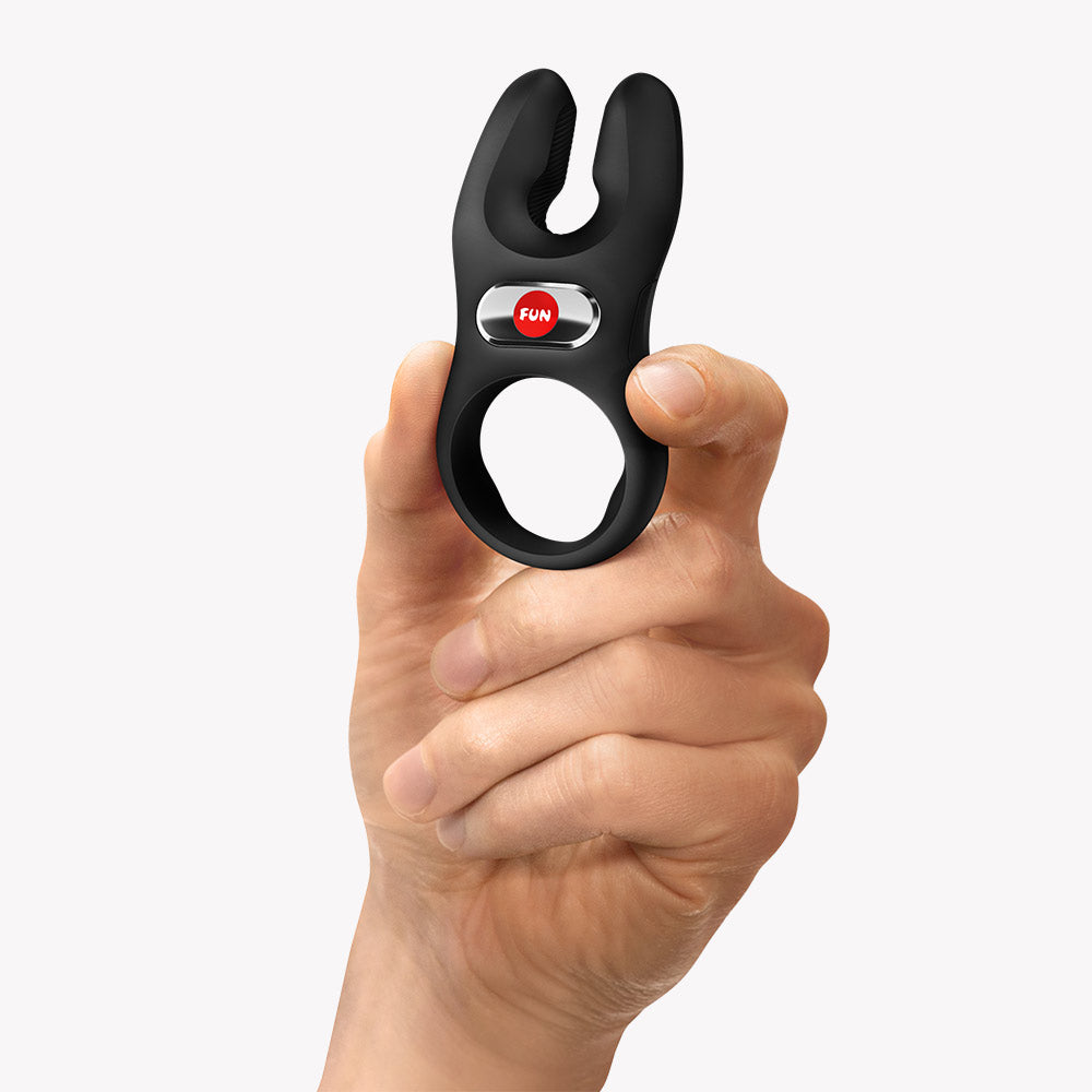 Fun Factory Nos Classic Vibrating Cock Ring Black held in hand, showcasing its ergonomic design and easy-to-use button.