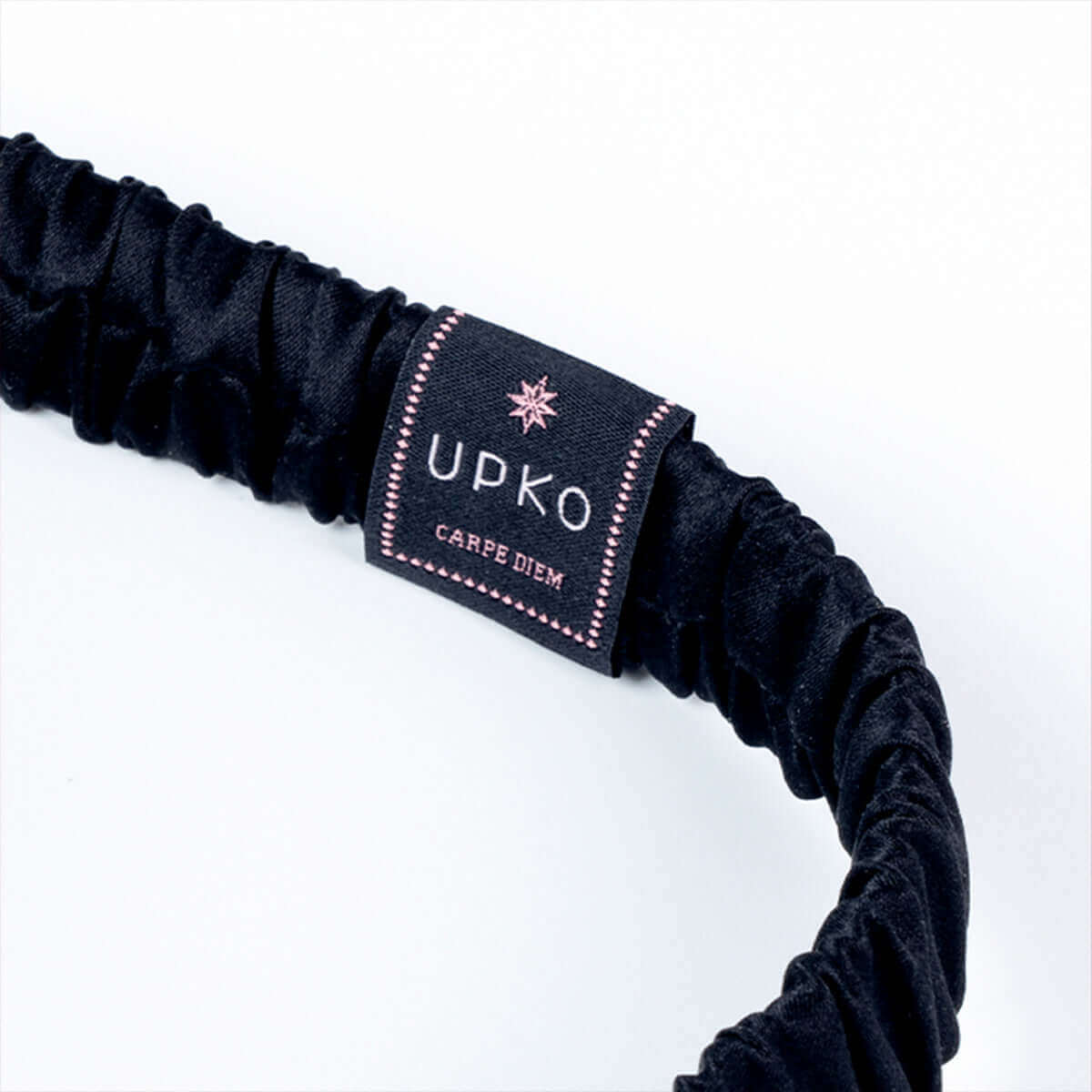 UPKO embroidered silk blindfold with a soft elastic band, featuring the brand label in a stylish, black design.