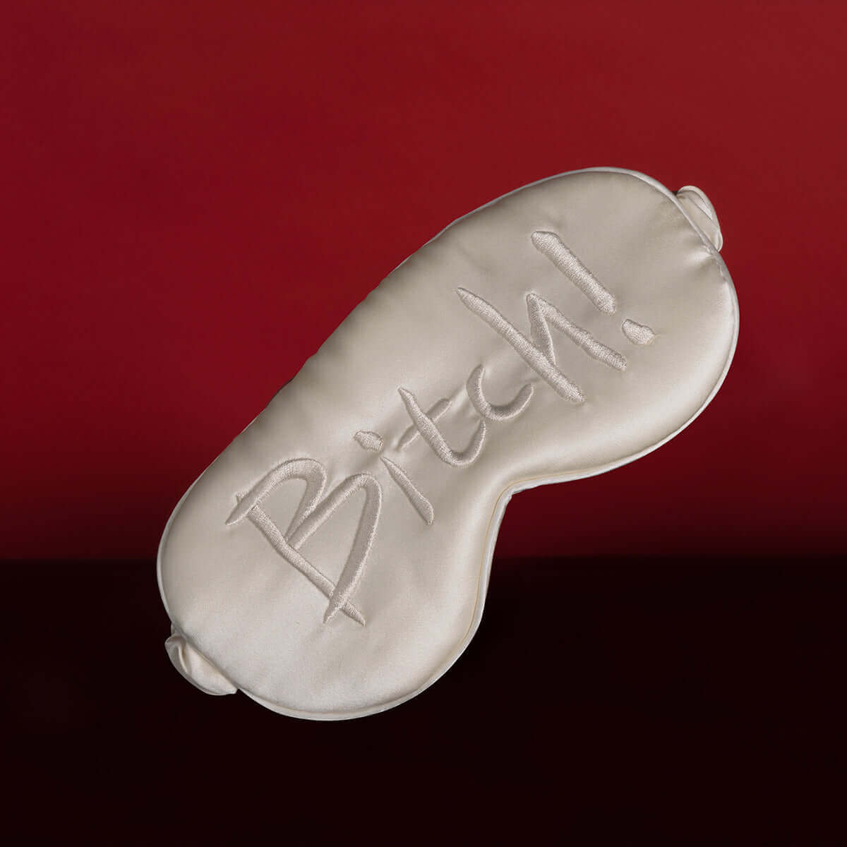 UPKO embroidered silk blindfold with the text "Bitch!" on a deep red background, made of soft mulberry silk for comfort.