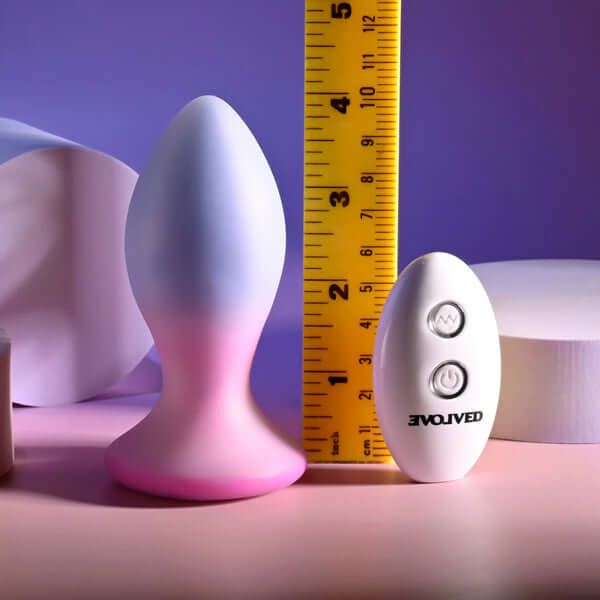 Paradise Rechargeable Silicone Plug in pink/purple with remote and measuring tape for size reference.