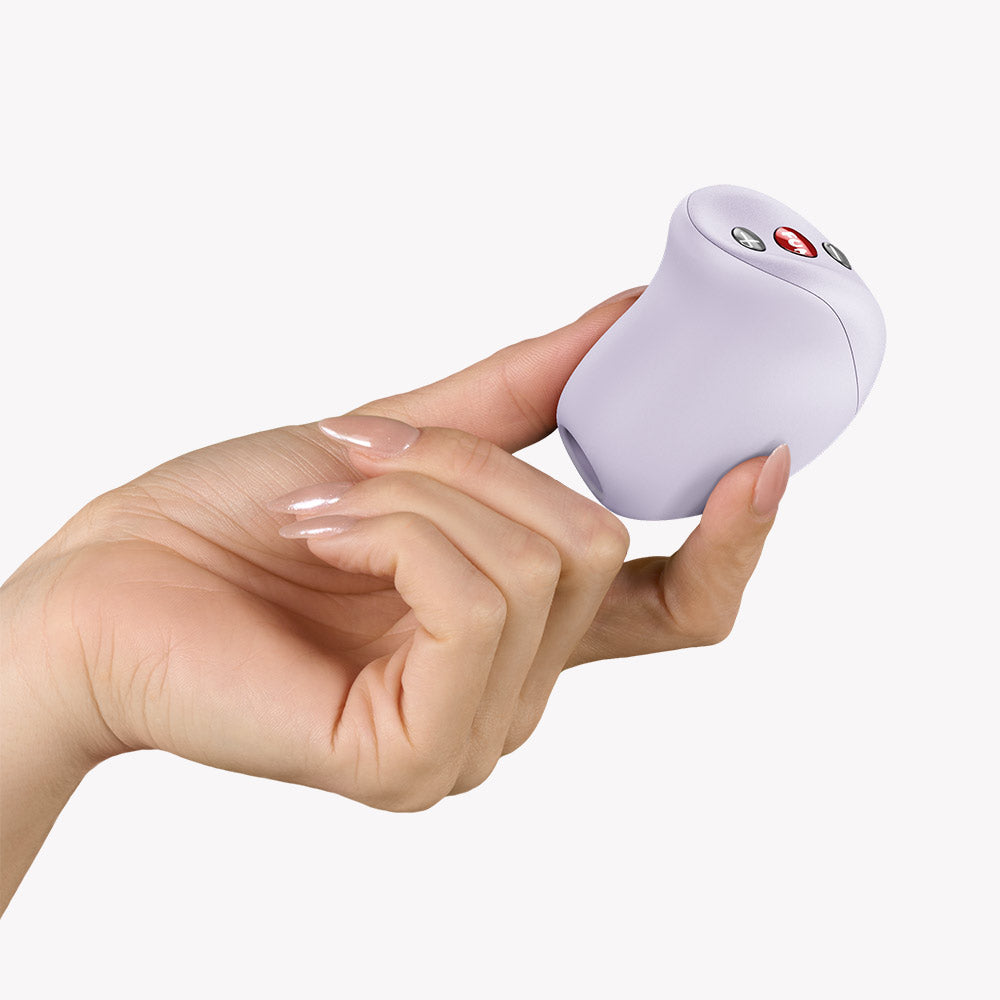 Fun Factory Mea Air Pulse Vibrator Purple held in hand, showcasing sleek design and control buttons.