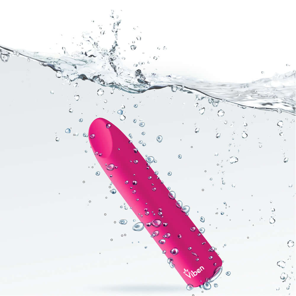 Viben's Fixation Hot Pink Lipstick Vibe submerged in water with splashes, showcasing its sleek design.