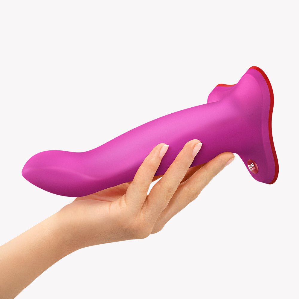 Fun Factory Limba Flex M Bendable Dildo Magenta held in a hand, showcasing its flexible design.