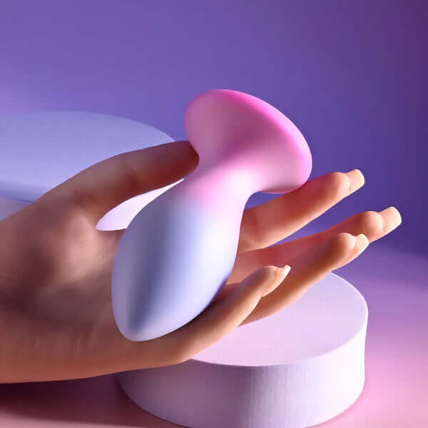 Paradise Rechargeable Silicone Plug in hand, showcasing its pink and purple dual-layer design.