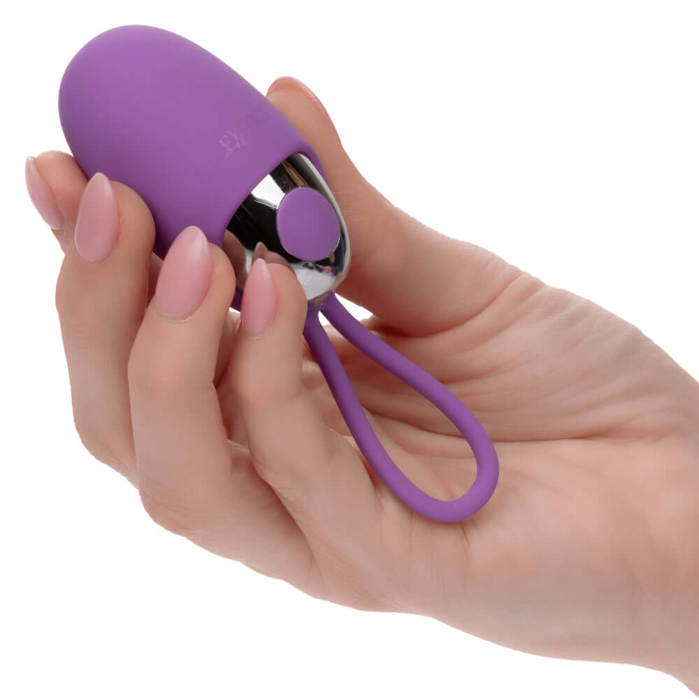 Hand holding purple Turbo Buzz Bullet with removable silicone sleeve, a compact and powerful vibrator for versatile pleasure.
