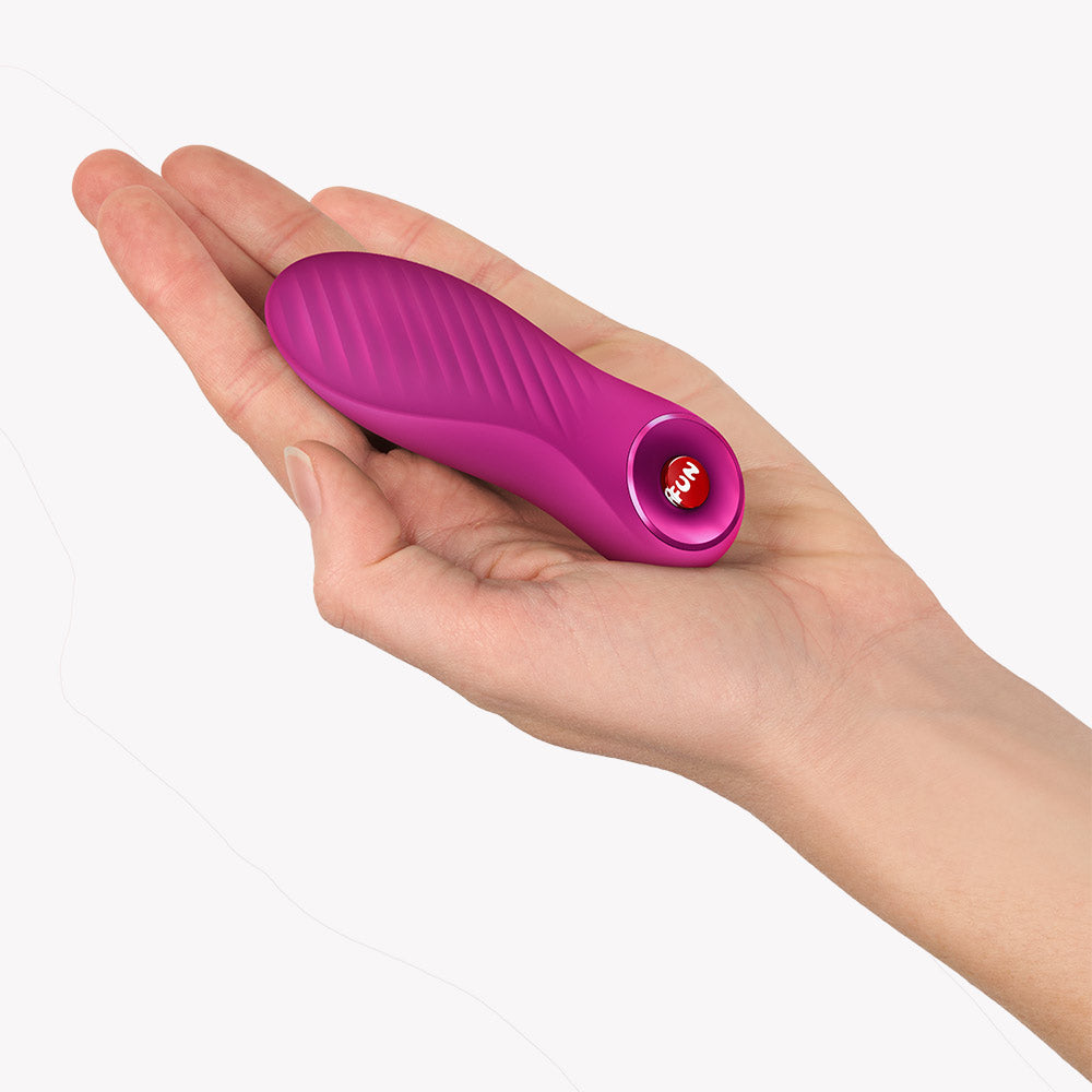 Fun Factory Bijou Bullet Vibrator Magenta held in a hand, showcasing its compact and portable design.
