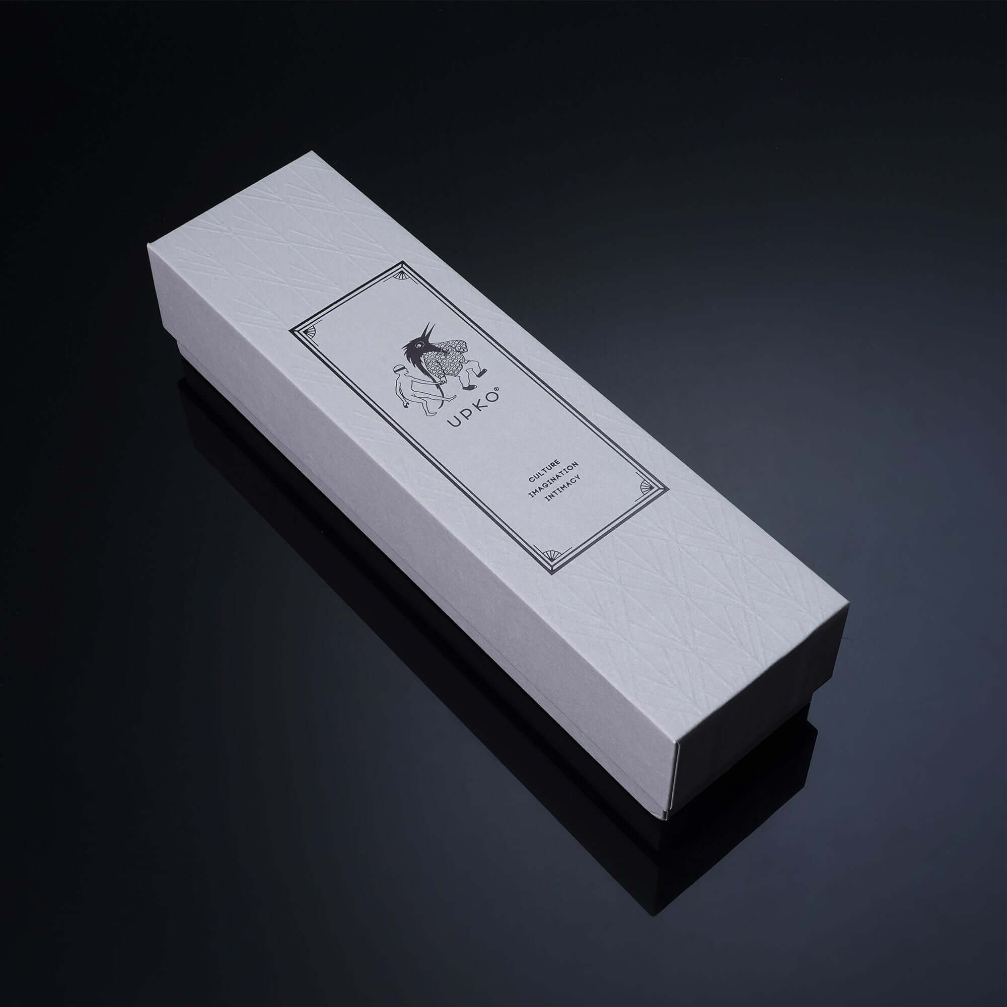 Elegant white packaging box featuring artistic label design for luxury product presentation.
