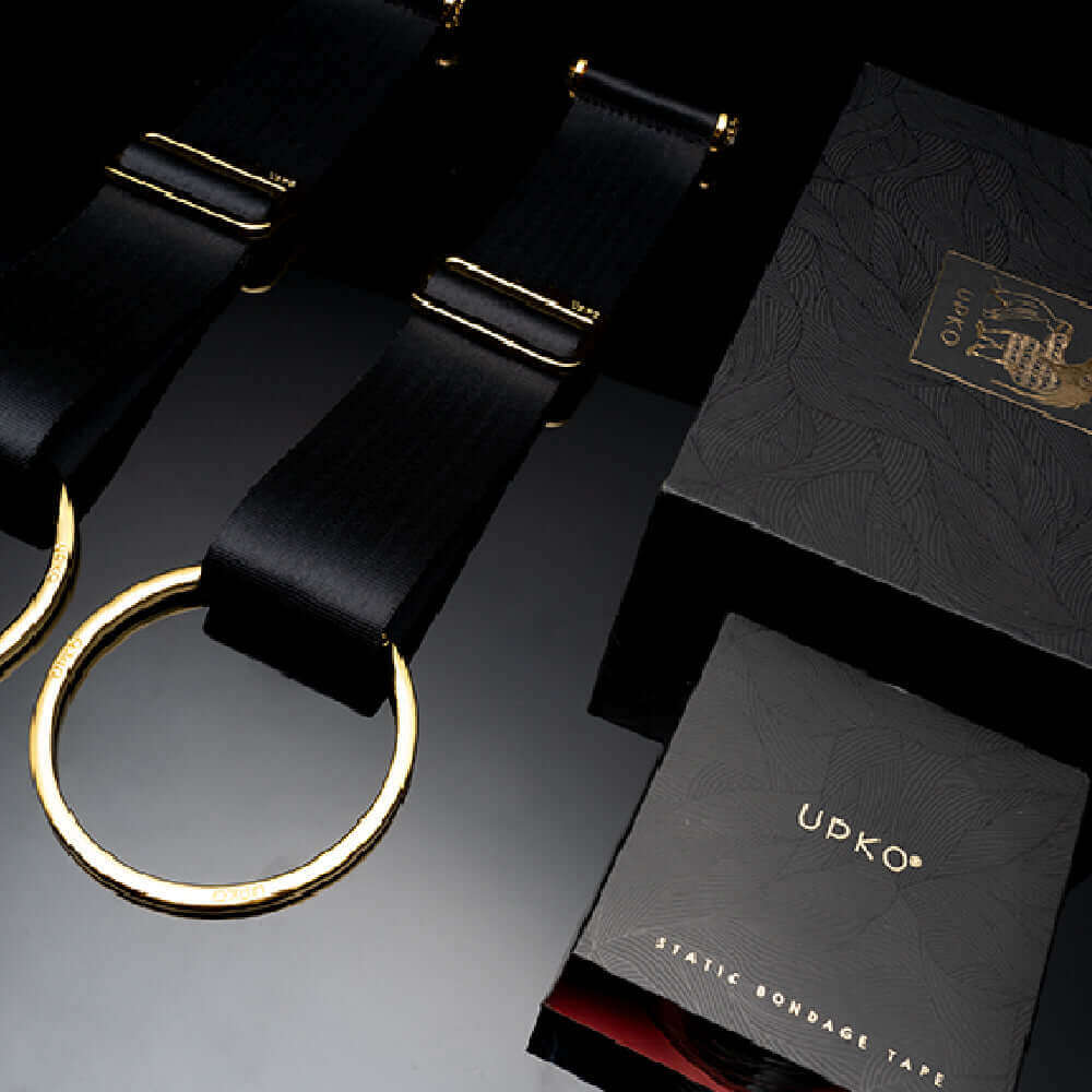 UPKO Over the Door Pair Wrist Restraints Set with black straps and gold rings, alongside stylish packaging.