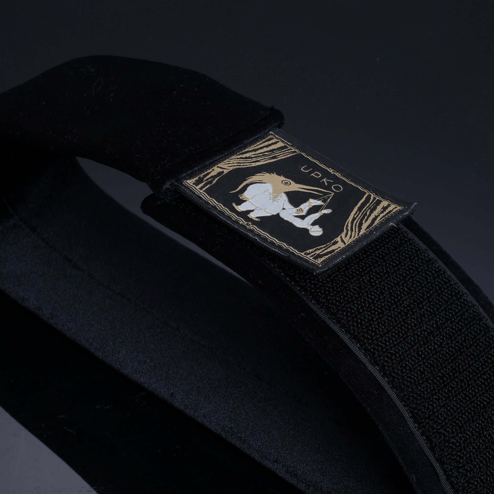 Close-up of Clack Bondage Restraints gear featuring a durable black strap with a stylish logo patch.