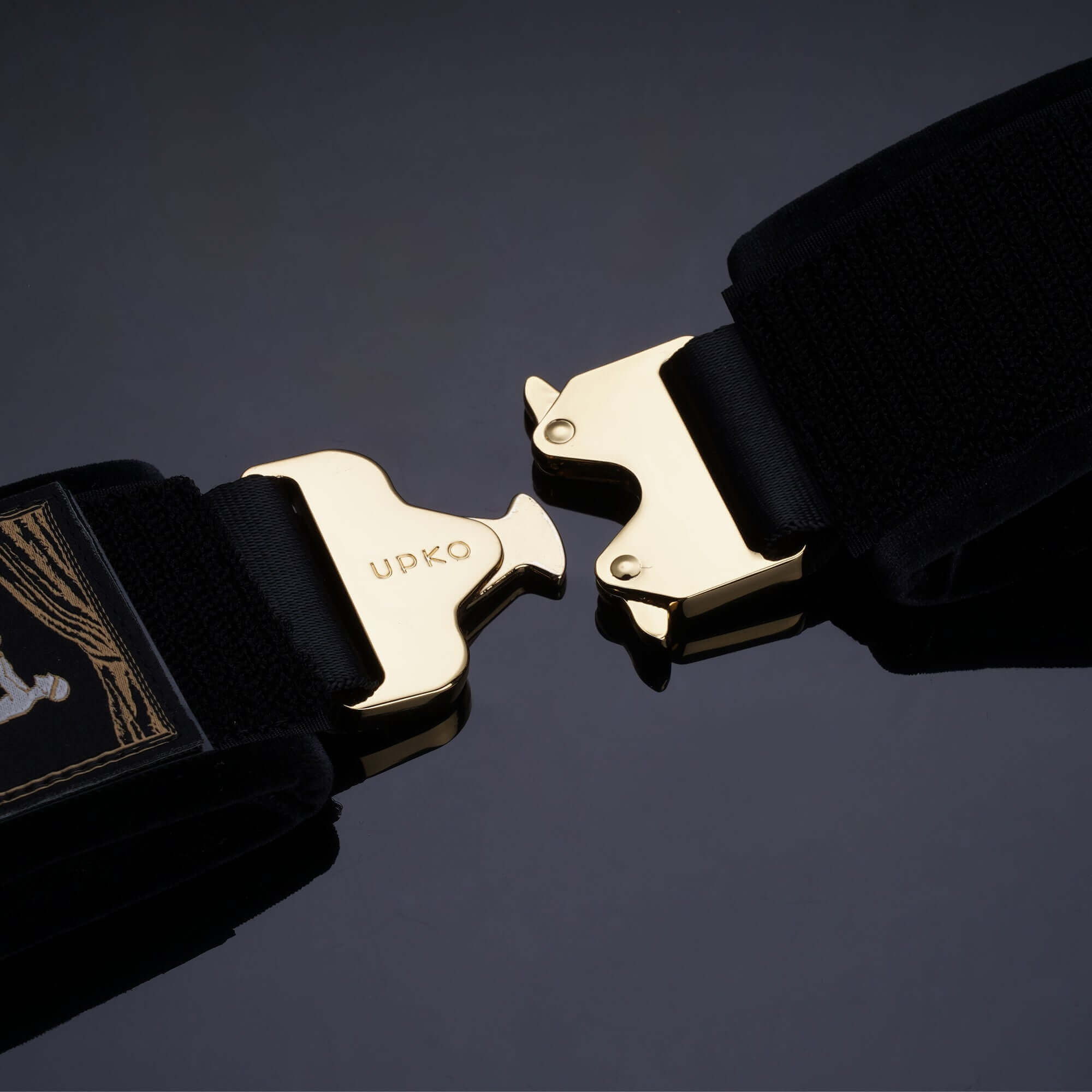 Clack Bondage Restraints gear featuring custom dual-sided buckles in gold on soft black straps.
