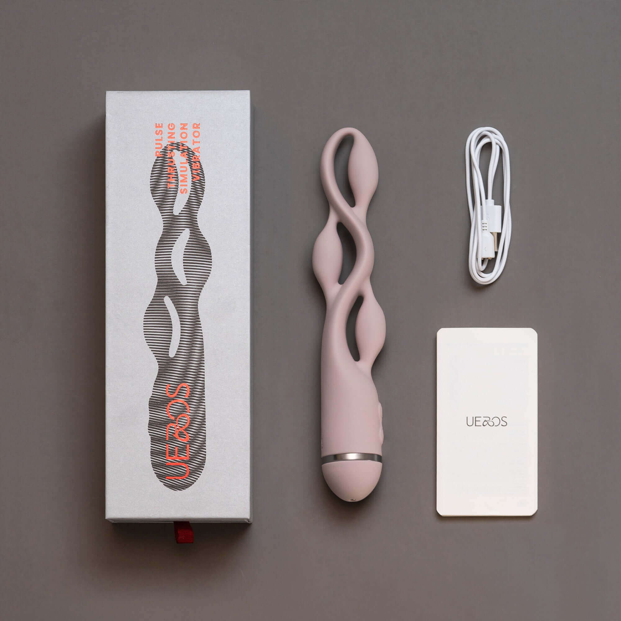 UEROS pink multi-motor pulse vibrator with unique design, packaging box, charging cable, and instruction manual displayed.