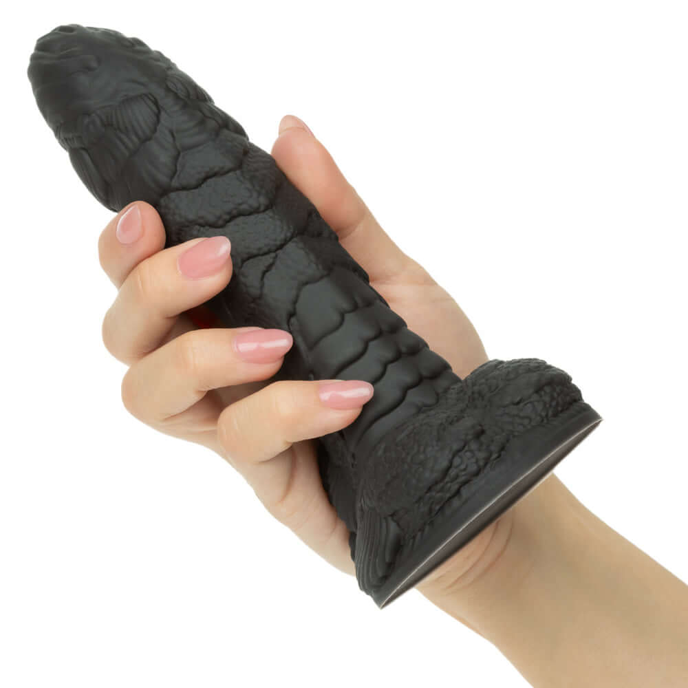 A hand holding the Monster Dong the Gill Man Dildo Black showcasing its detailed texture and premium silicone material.