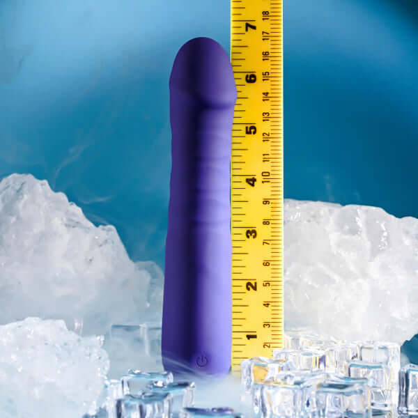 Selopa Ambition rechargeable silicone thrusting vibrator shown on ice with a measuring tape for size reference.
