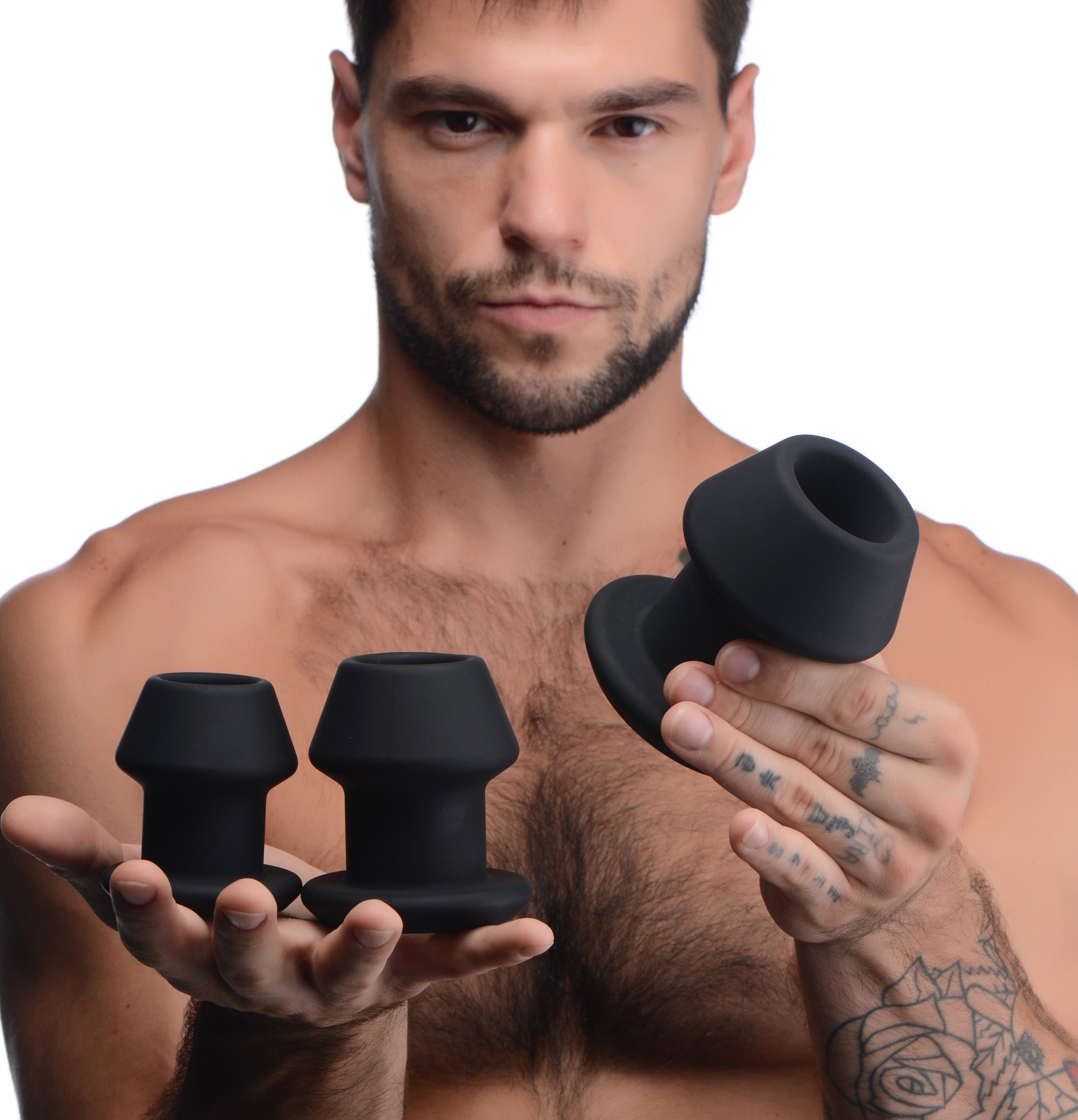 Gape-Grommets 3 Piece Hollow Silicone Anal Dilator Set held by a man showcasing the three progressively sized dilators.