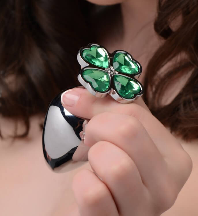 Lucky Clover Gem Anal Plug Small Booty Sparks with green clover-shaped jewel held by a hand.