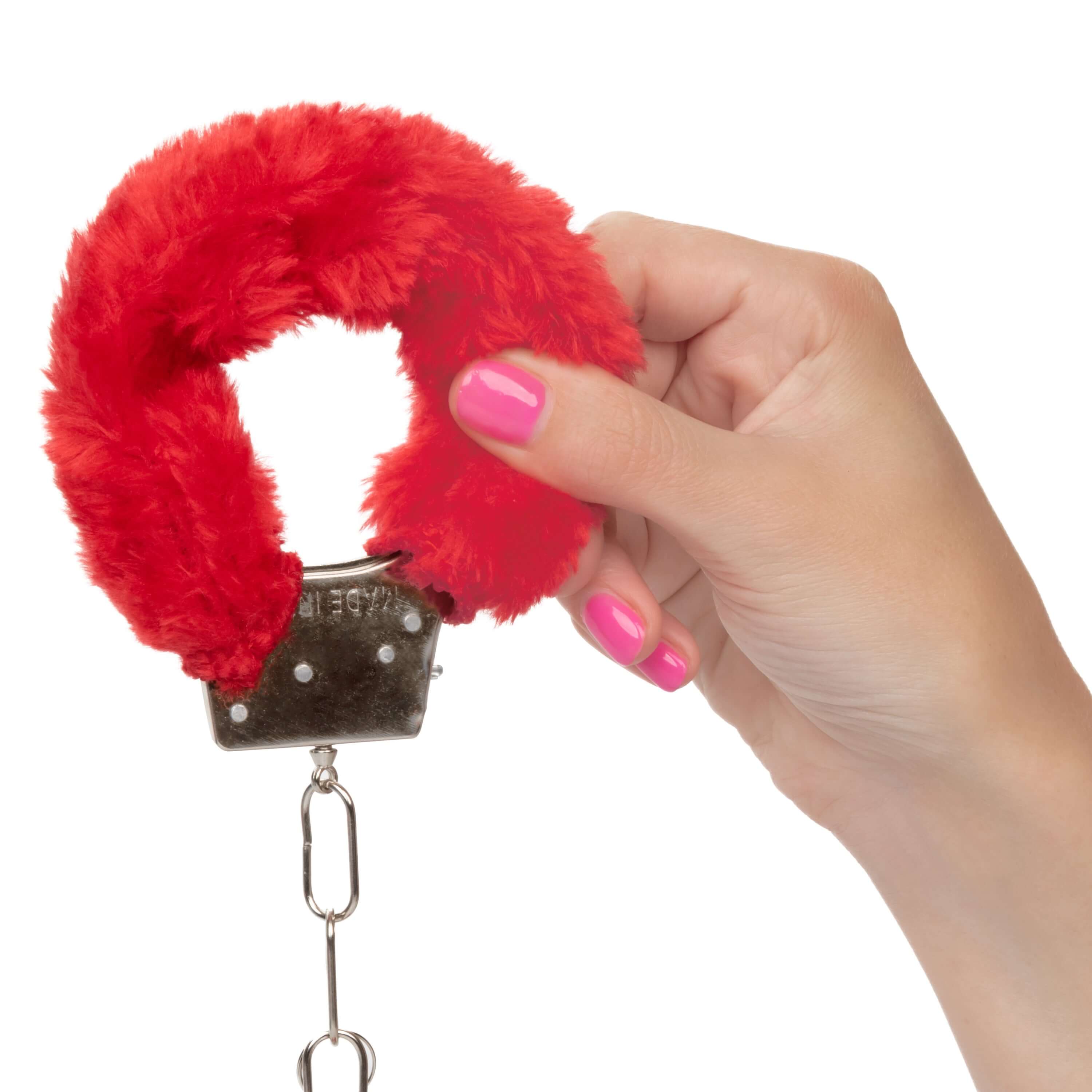 Close-up of hand holding Playful Furry Cuffs Red, showcasing their colorful and soft design for intimate play.