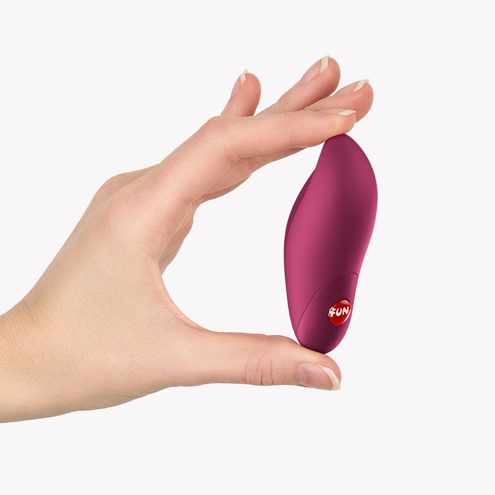 Fun Factory Charme Bullet Vibrator Wine Red held in hand, showcasing its compact and ergonomic design.