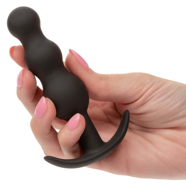 Hand holding a black Boundless Vibrating Beaded Plug showcasing its smooth, tapered, beaded design for enhanced pleasure.