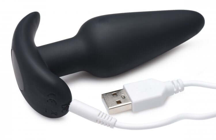 Bang 21x Silicone Butt Plug With Remote Black connected to USB for charging, showing sleek design and tapered tip.