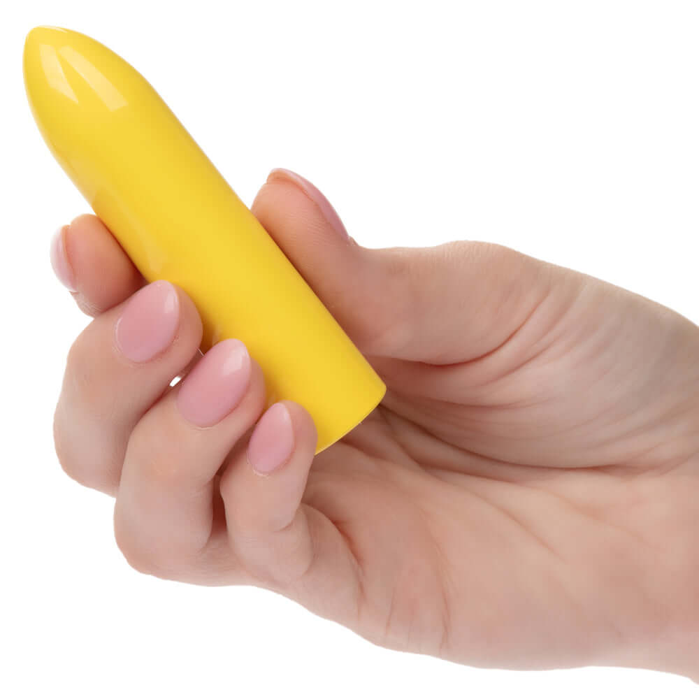 Woman holding yellow Turbo Buzz Classic Bullet vibrator with smooth design