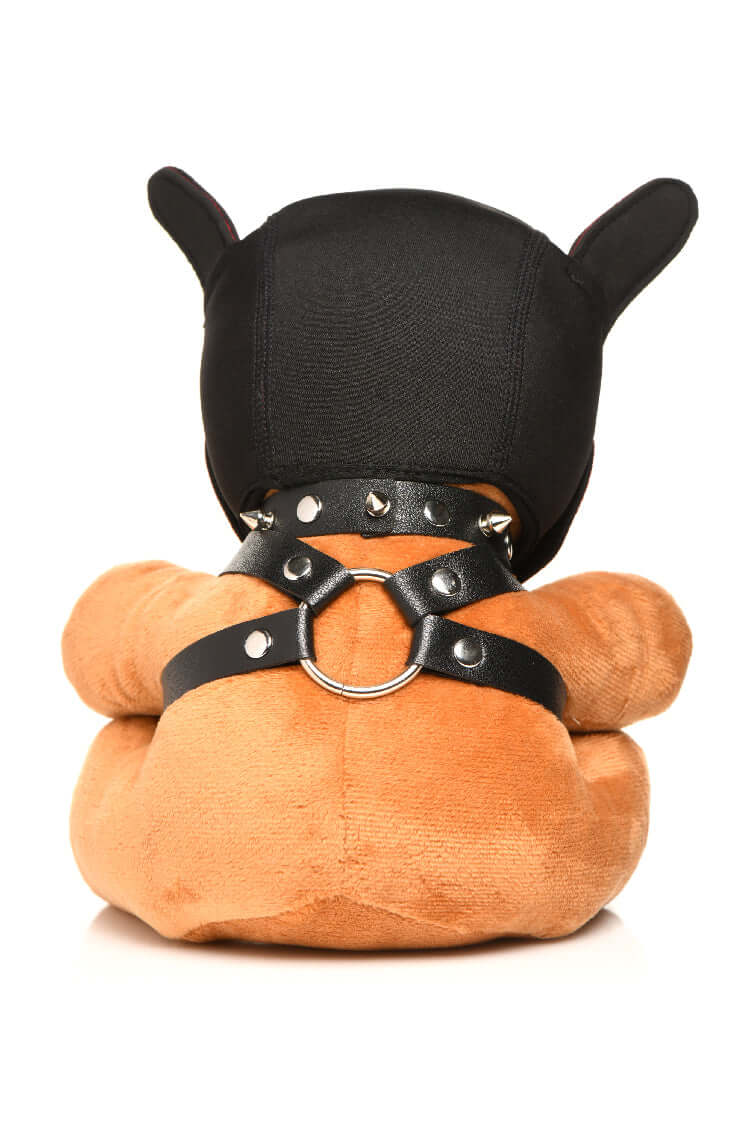 Bondage Pup Bear with light peach fur, puppy mask, and faux leather harness with metal O-rings sitting on a white background.
