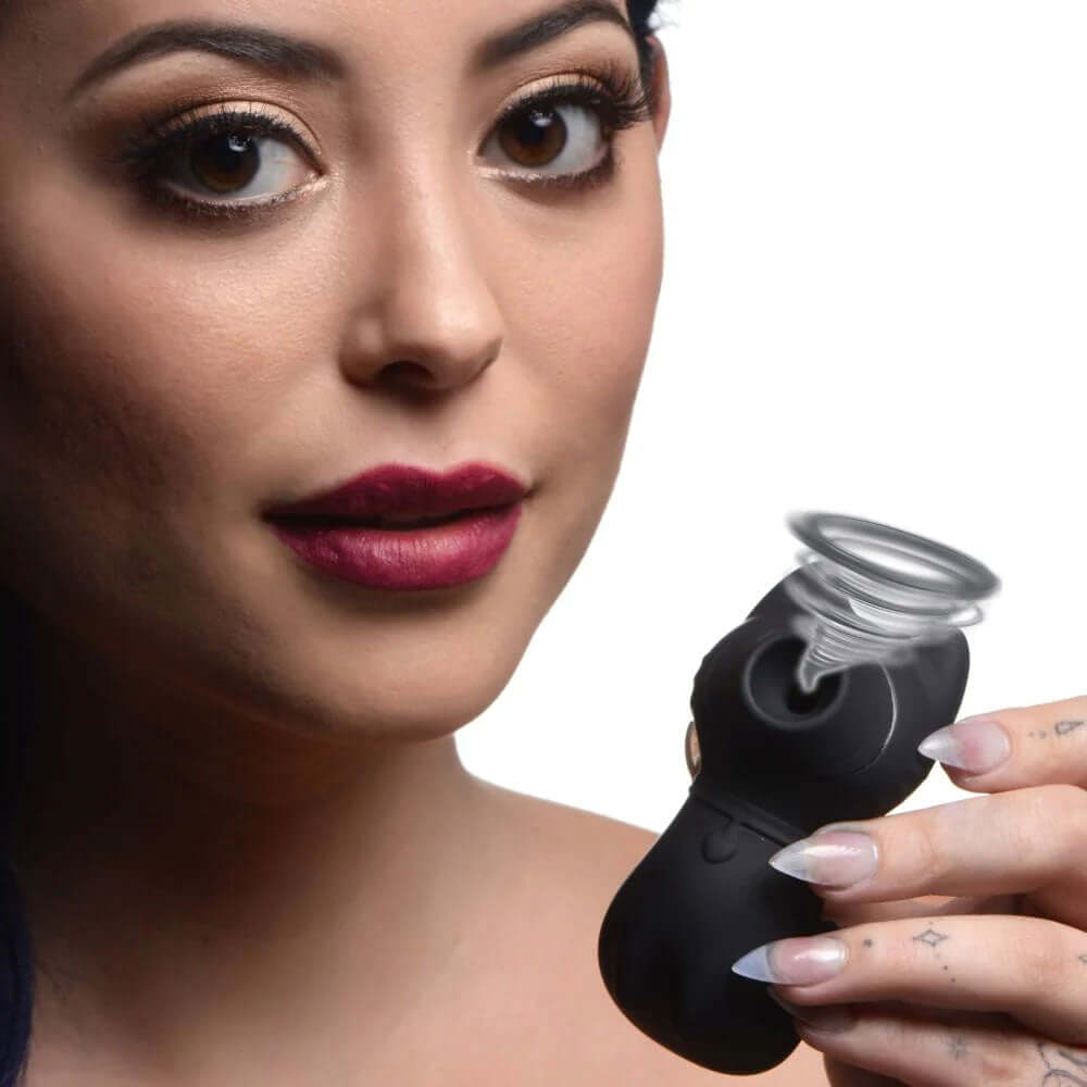 Woman holding the Sucky Kitty 7x Clitoral Stimulator Black, showcasing its design and suction features.