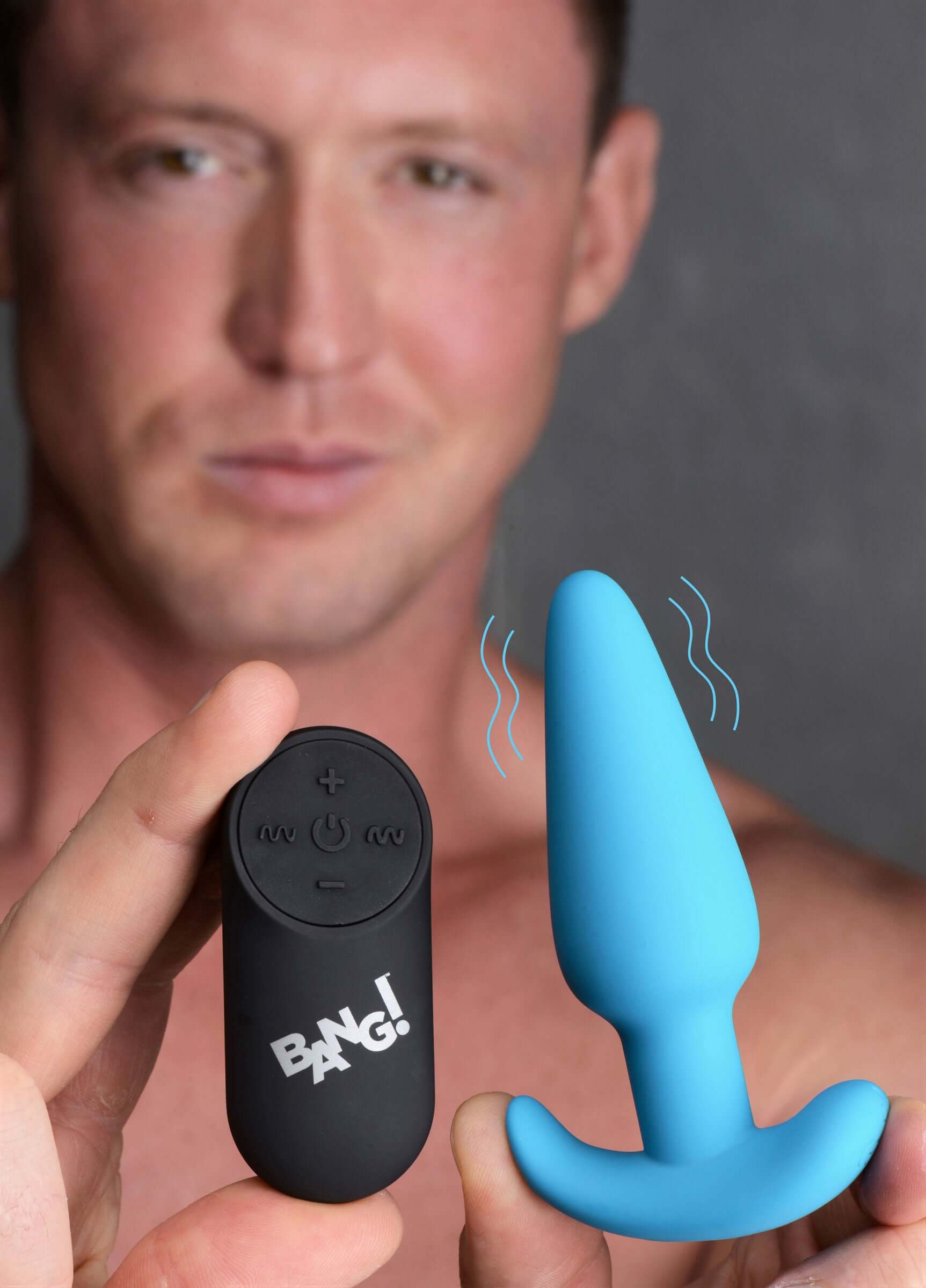Bang 21 X Silicone Butt Plug With Remote Blue held by a man, showcasing the remote control and the vibrating anal plug.