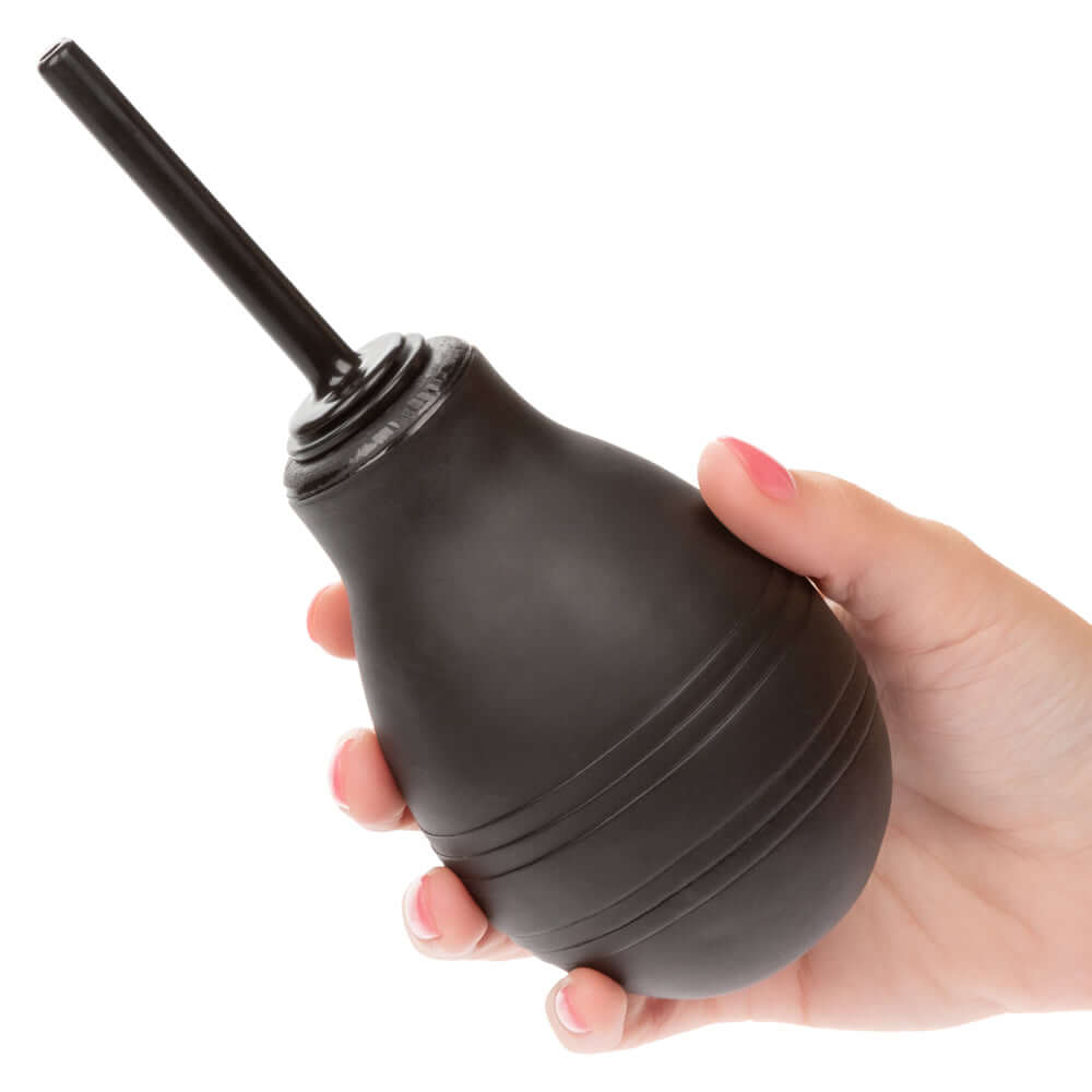 One Way Anal Douche Black held in a hand, featuring a slender ergonomically shaped nozzle for comfortable cleansing.