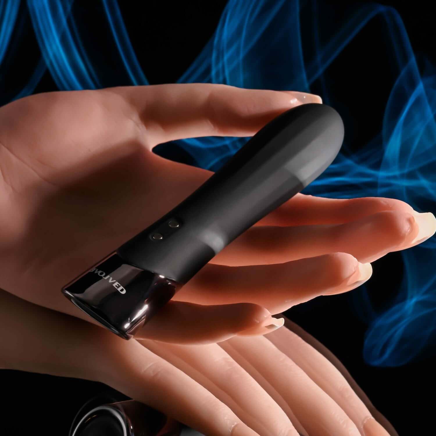Sleek black vibrator with chrome tip, resting in a hand, showcasing its ergonomic design and one-button control.