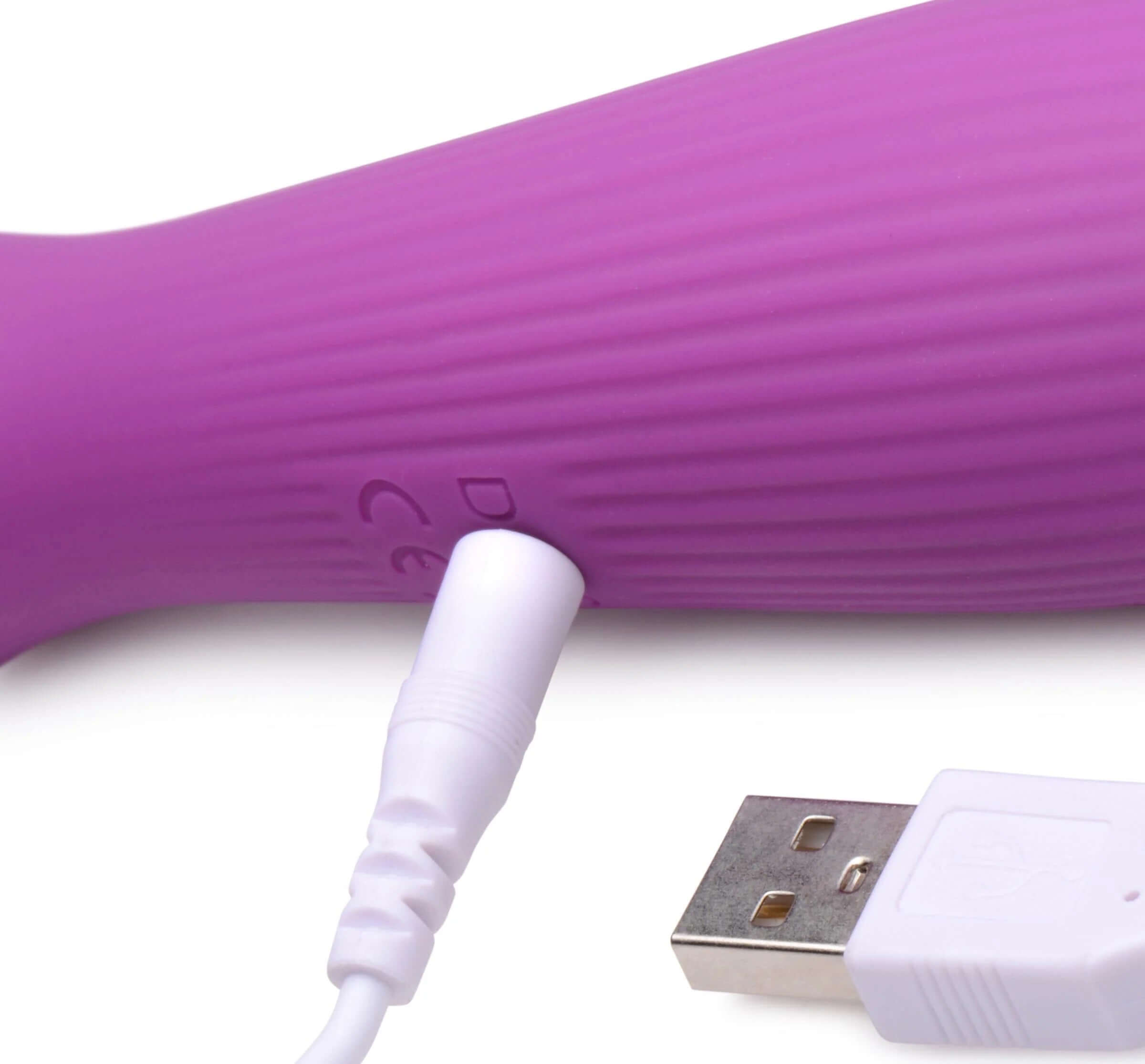 Violet silicone wand massager with USB charging cable inserted, featuring textured handle for extra stimulation.