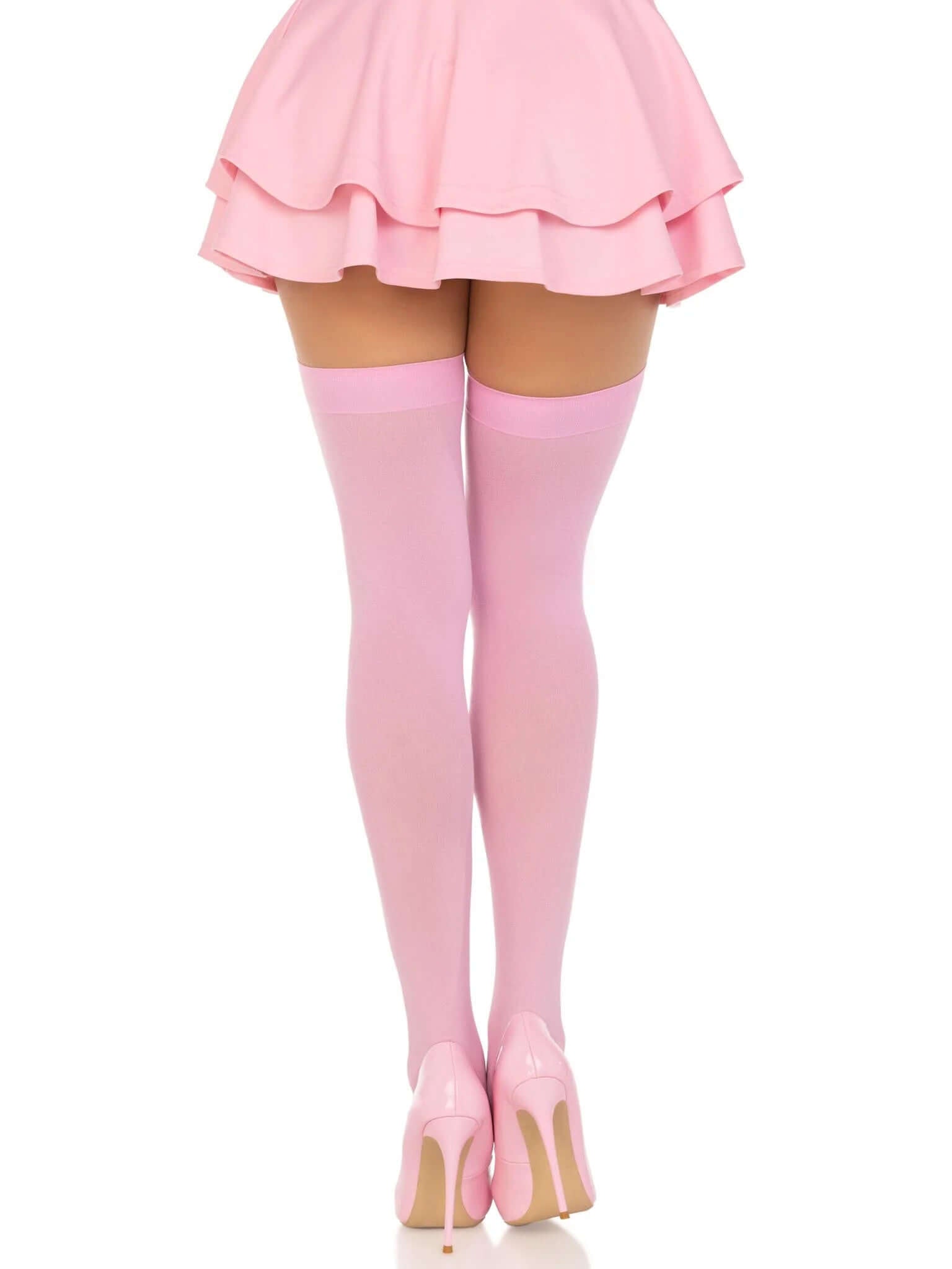 Woman wearing pink opaque nylon thigh highs and matching skirt, showcasing stylish and comfortable hosiery from Leg Avenue.
