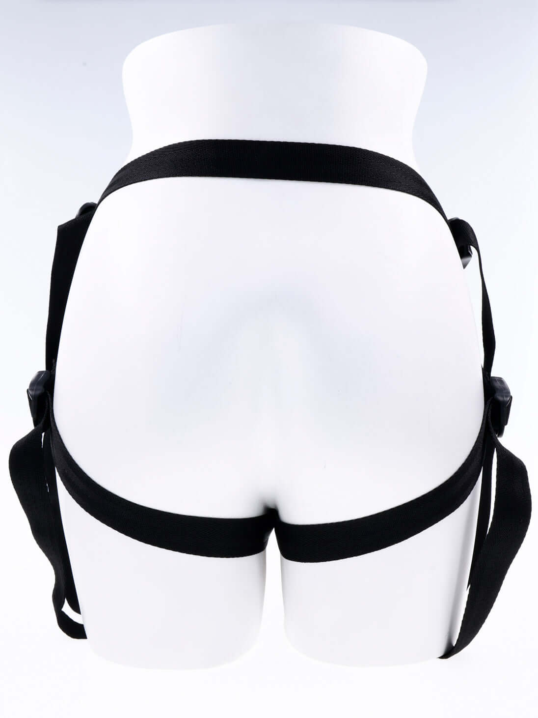 Rear view of mannequin wearing Dual Desires Strap On harness in black with adjustable straps.