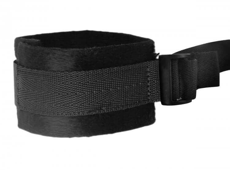 Close-up of a black faux fur cuff from the Hold Me Under the Bed Restraint System with adjustable buckle and secure strap.