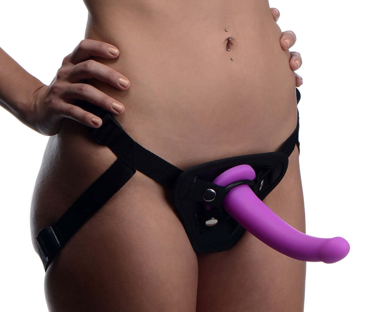 Person wearing adjustable harness with attached silicone G-Spot dildo for pegging or vaginal penetration.